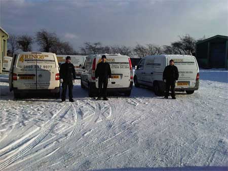 4 Ring's mechanics in behind their vans in the snow